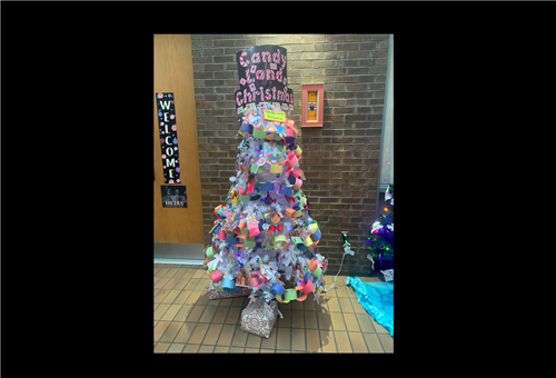 Christmas Tree decorated with colorful with a sign that says candy land Christmas